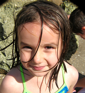 little girl at Deerfield Beach beach smiling at the ocean